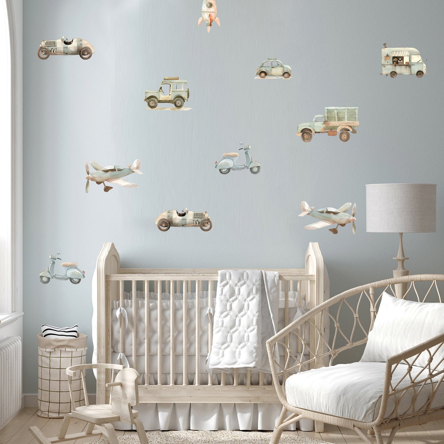 Nursery room with crib, rocking chair, and wall decals of vehicles and airplanes.