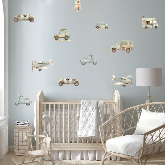 Nursery room with crib, rocking chair, and wall decals of vehicles and airplanes.